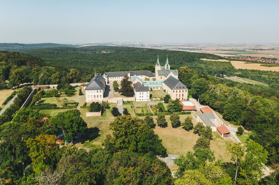 Eine Drohnenaufnahme der Huysburg mit dem Huy und Dingelstedt im Hintergrund